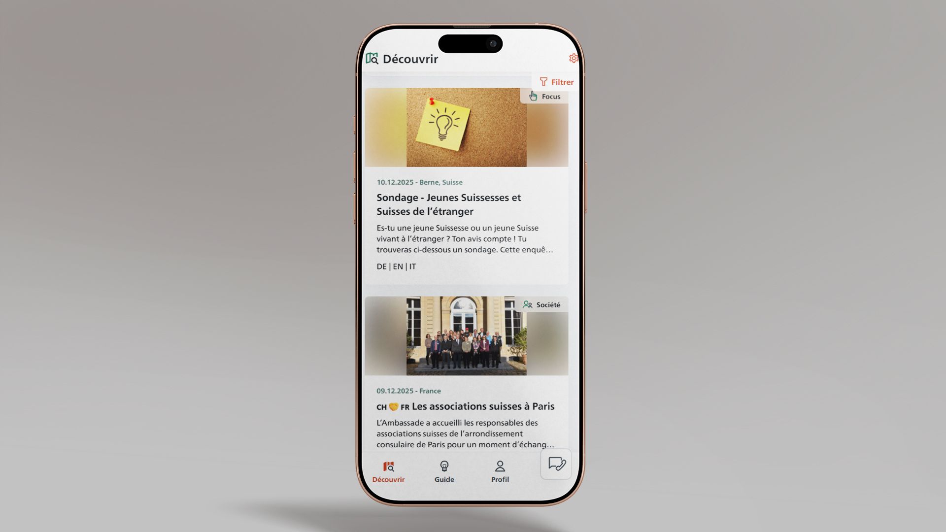 L’image montre un smartphone sur lequel l’application SwissInTouch est ouverte sur le flux de publications. Deux contributions sont visibles.